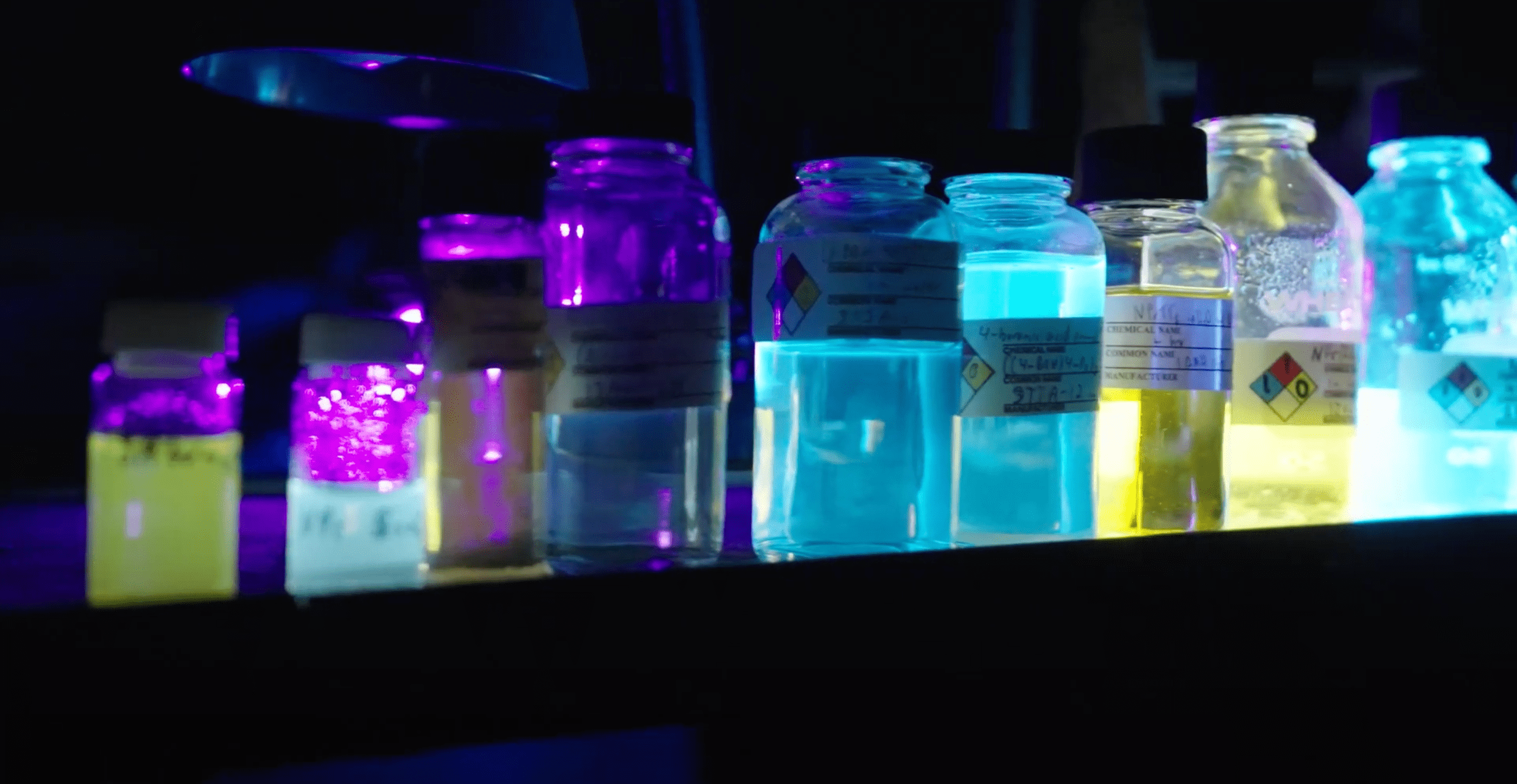 Beakers of different neon colors of fluids on a bench